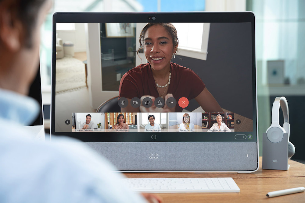 Ein Mann nimmt &uuml;ber seine Webex Desk Pro an einem Online-Meeting teil. Neben der Desk Pro steht sein Cisco 730 Headset.