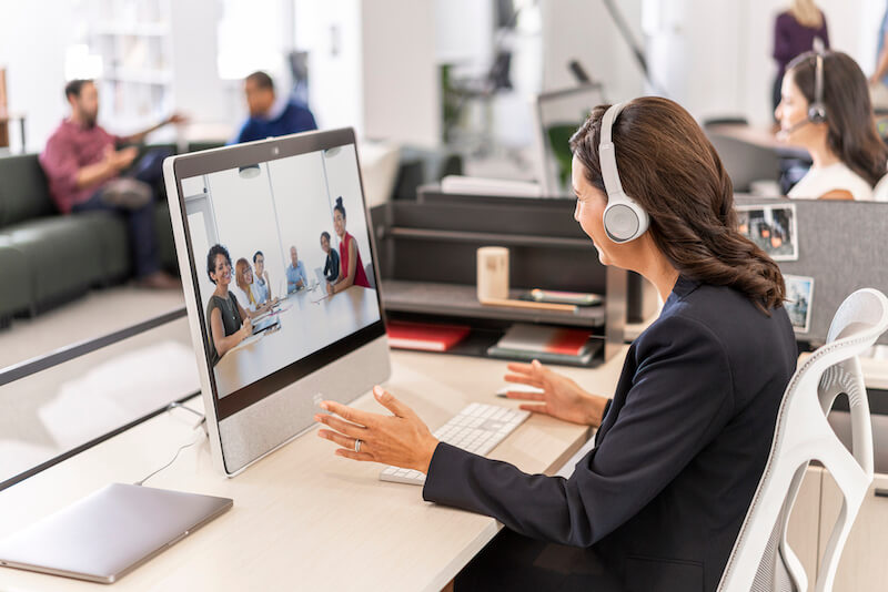 Eine Frau nutzt das Cisco 730 Headset und die Webex Desk f&uuml;r Videomeetings aus dem B&uuml;ro